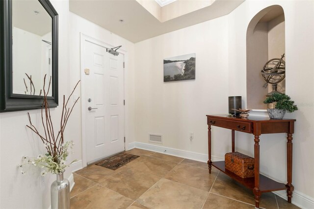 tiled foyer entrance featuring a skylight