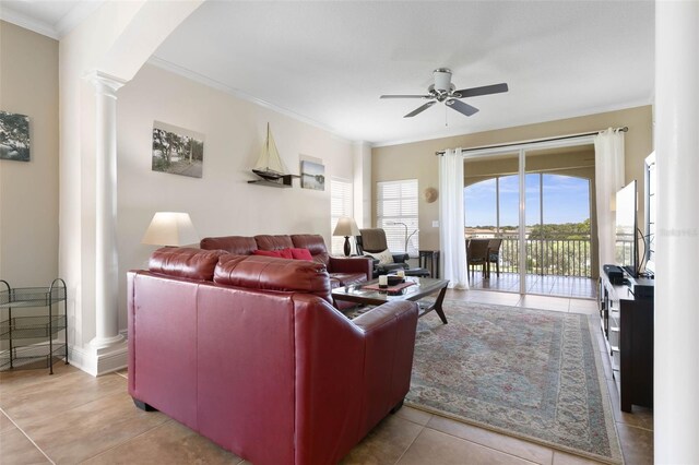 living room with decorative columns, ceiling fan, light tile patterned flooring, and ornamental molding