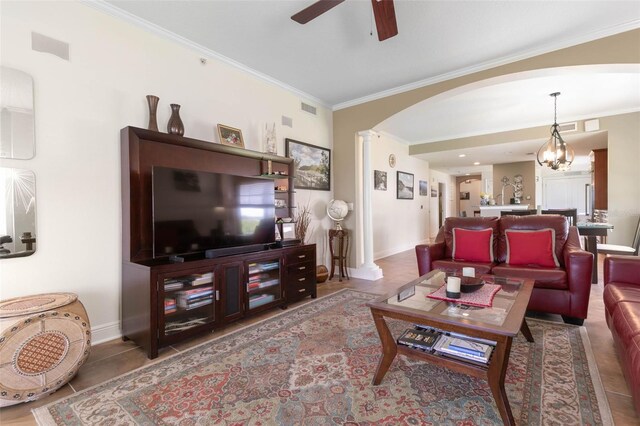 living room with ceiling fan with notable chandelier and ornamental molding