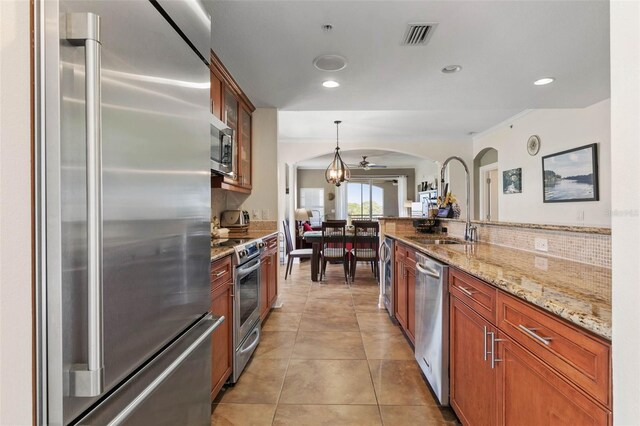 kitchen featuring stainless steel appliances, light tile patterned floors, pendant lighting, ceiling fan, and backsplash