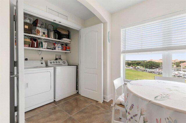 laundry area with washing machine and dryer and tile patterned floors