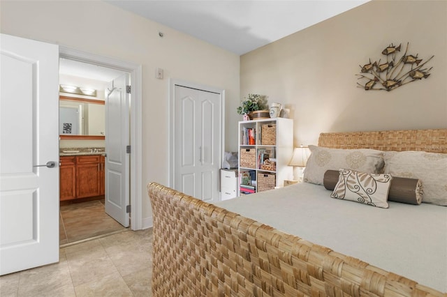 tiled bedroom featuring connected bathroom and a closet