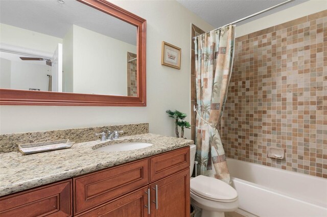 full bathroom with ceiling fan, shower / tub combo, vanity, and toilet