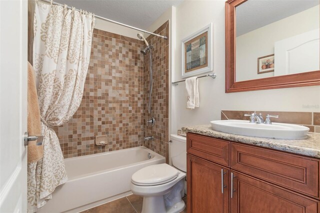 full bathroom with a textured ceiling, toilet, tile patterned floors, shower / bath combo with shower curtain, and vanity