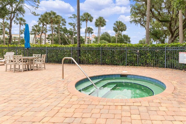 view of pool with a hot tub and a patio