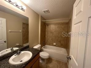 full bathroom featuring vanity, a textured ceiling, tile patterned floors, toilet, and tiled shower / bath