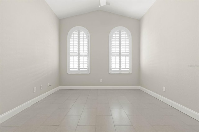 spare room with light tile patterned floors and vaulted ceiling