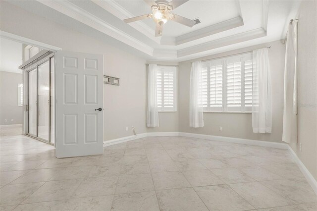 empty room featuring ceiling fan, crown molding, and a tray ceiling