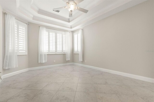 spare room with ornamental molding, ceiling fan, and a raised ceiling