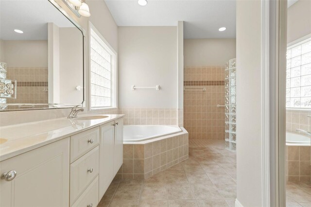 bathroom featuring vanity, tile patterned floors, and plus walk in shower