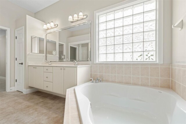 bathroom featuring tiled bath, tile patterned flooring, and vanity