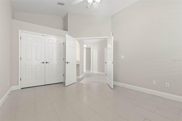 unfurnished bedroom with ceiling fan, a closet, and high vaulted ceiling