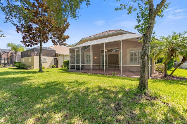 back of property with a lawn and glass enclosure