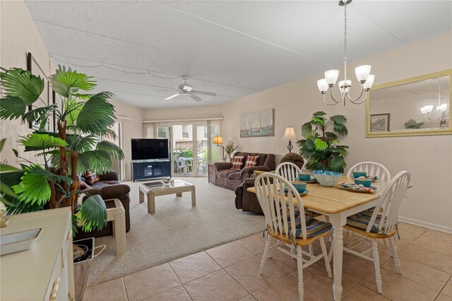 tiled dining room with ceiling fan with notable chandelier