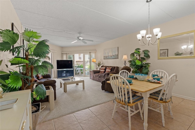 dining room with ceiling fan with notable chandelier, light tile patterned flooring, and light colored carpet