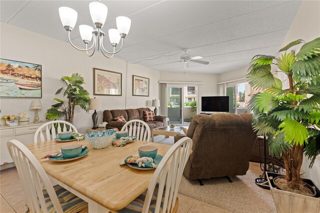 dining space with ceiling fan with notable chandelier and light tile patterned floors