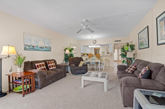 carpeted living room with ceiling fan and a textured ceiling