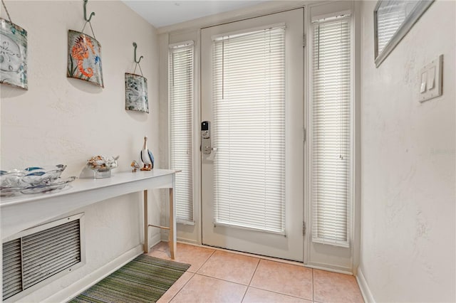 entryway with visible vents, a textured wall, baseboards, and light tile patterned floors