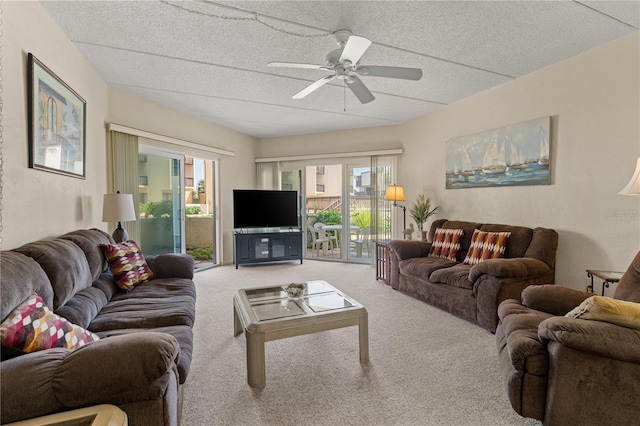 living room with carpet, plenty of natural light, ceiling fan, and a textured ceiling