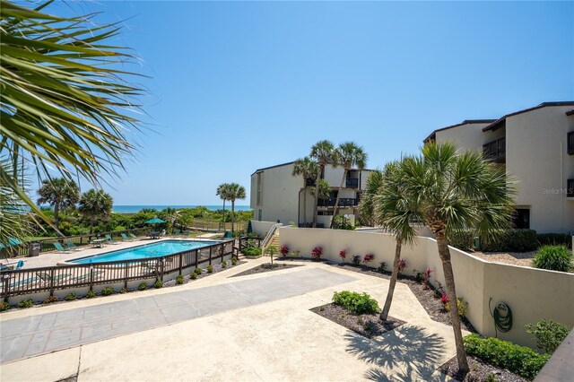 view of patio featuring a fenced in pool and a water view