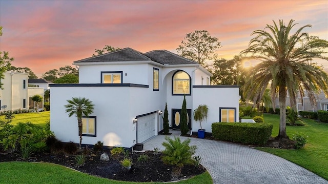 view of front of house featuring a garage and a yard