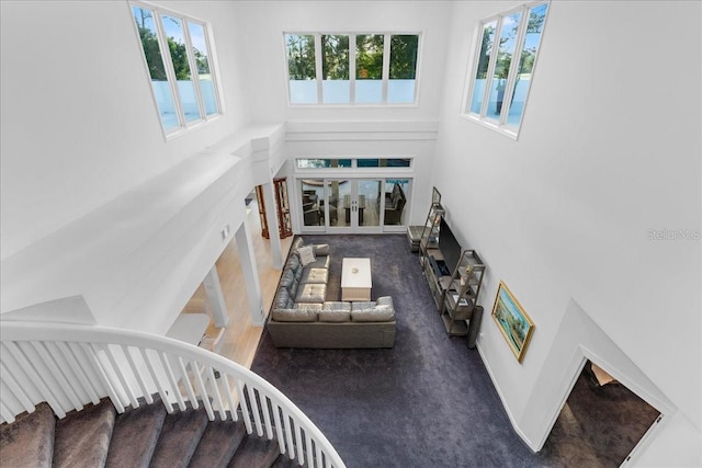 stairway with a high ceiling and dark carpet