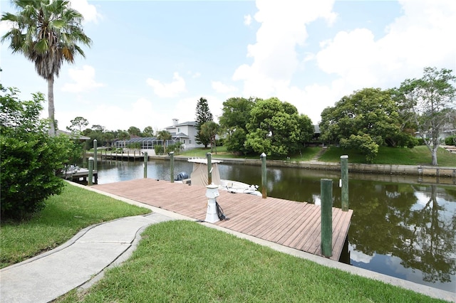 view of dock with a yard and a water view