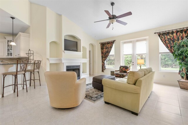 tiled living room with french doors, high vaulted ceiling, and ceiling fan