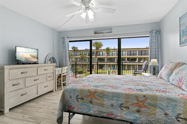 bedroom featuring a textured ceiling, wood finish floors, a ceiling fan, and access to exterior