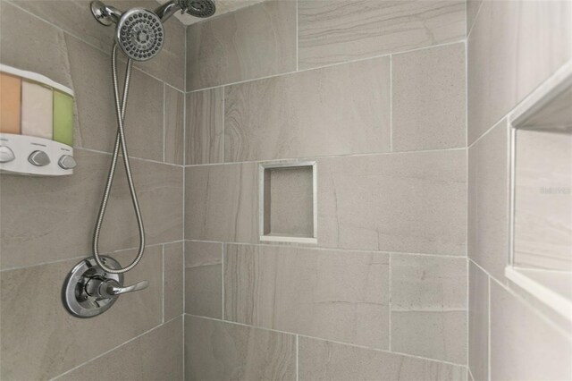 interior details featuring tiled shower