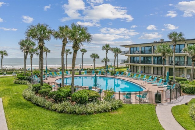 view of pool with a lawn and a water view