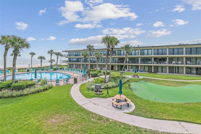 view of community with a pool and a lawn