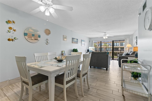 dining area featuring a ceiling fan, wood finish floors, and a textured ceiling