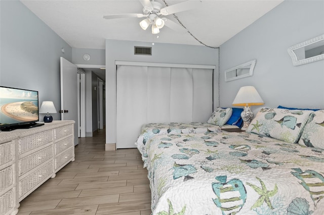 bedroom featuring ceiling fan, visible vents, a closet, and wood finish floors