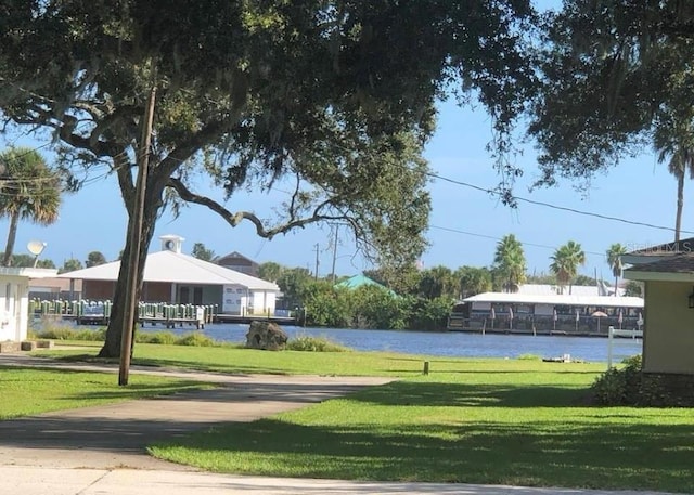 view of property's community featuring a lawn and a water view