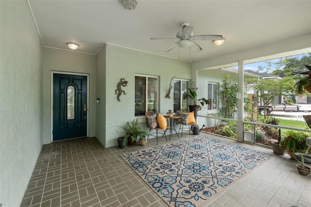 sunroom / solarium featuring a ceiling fan