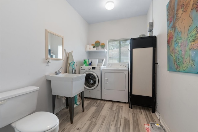 laundry area featuring light wood-type flooring, laundry area, baseboards, and washing machine and clothes dryer