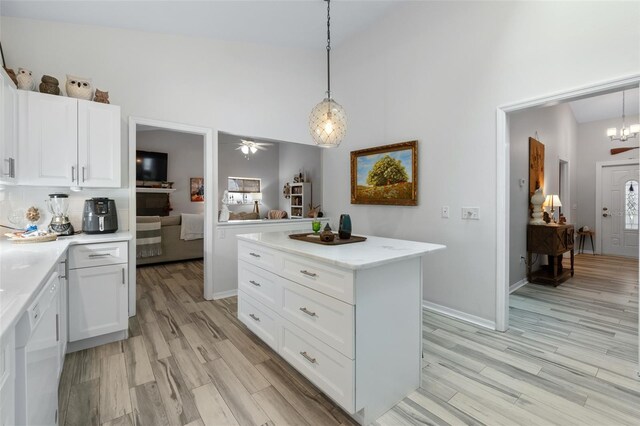 kitchen with white cabinets, dishwasher, decorative light fixtures, and light wood finished floors