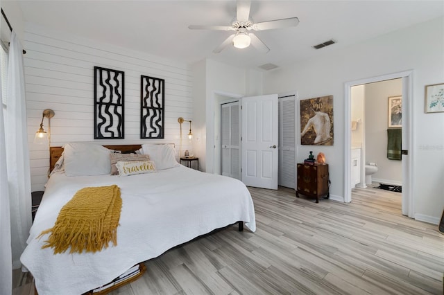 bedroom with visible vents, baseboards, a ceiling fan, ensuite bath, and light wood-type flooring