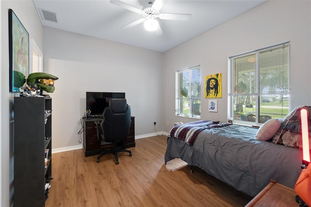 bedroom featuring a ceiling fan, light wood-type flooring, visible vents, and baseboards