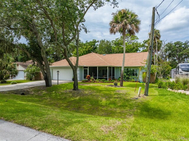 ranch-style home featuring driveway, a front lawn, an attached garage, and a sunroom