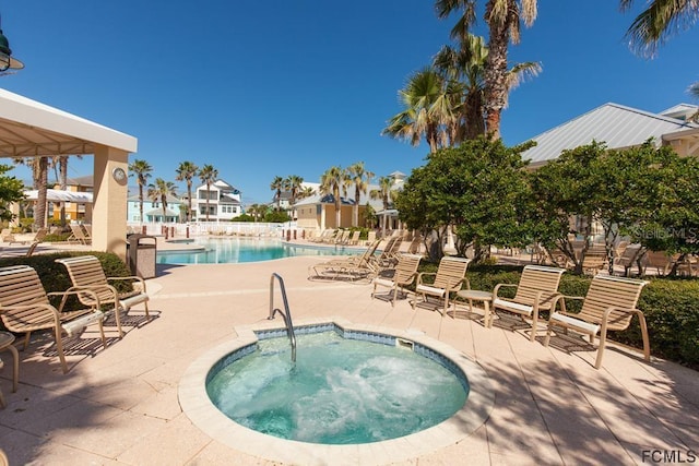 view of pool featuring a hot tub and a patio area