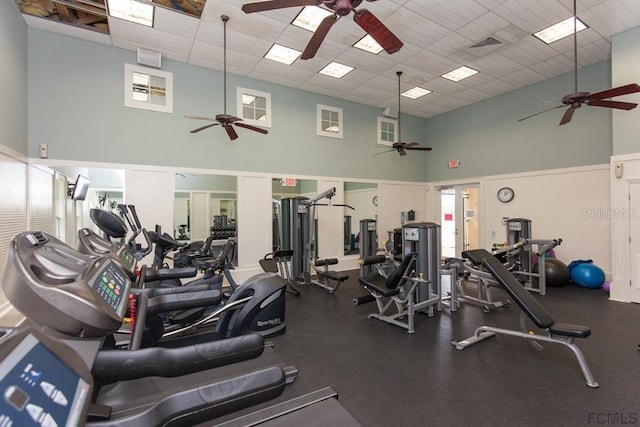 exercise room featuring ceiling fan and a towering ceiling