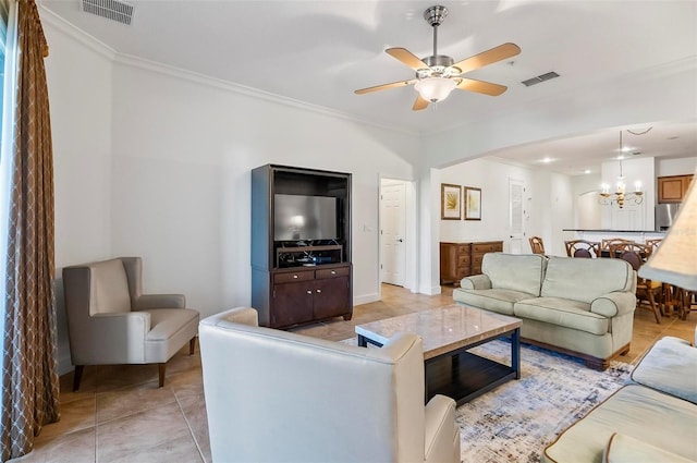 tiled living room featuring ceiling fan with notable chandelier and ornamental molding