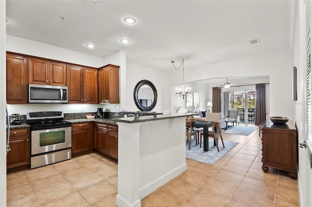 200 Cinnamon Beach Way Unit 122, Palm Coast, FL 32137 - kitchen featuring stainless steel appliances, a peninsula, light tile patterned flooring, dark stone countertops, and crown molding