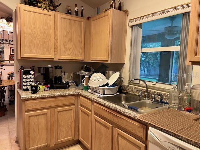 kitchen with light brown cabinets, dishwashing machine, light stone countertops, light tile patterned floors, and sink