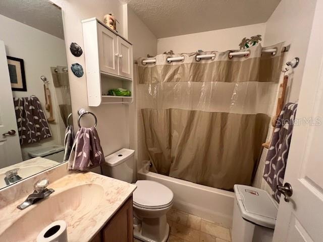 full bathroom featuring a textured ceiling, toilet, tile patterned flooring, shower / bath combo with shower curtain, and vanity