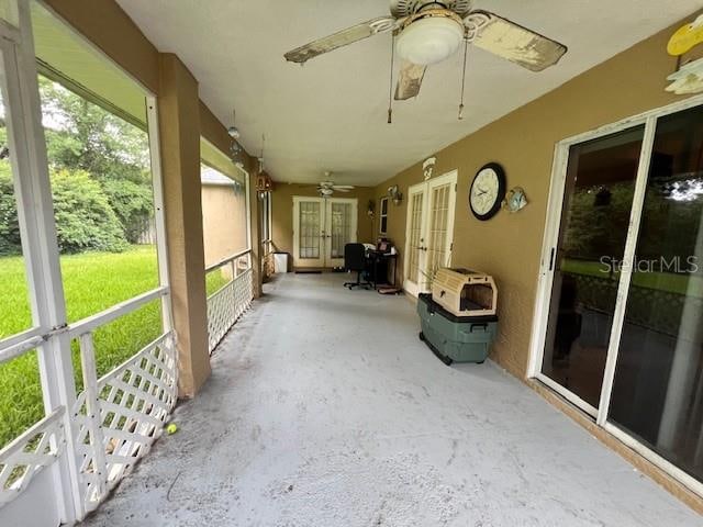 unfurnished sunroom with ceiling fan