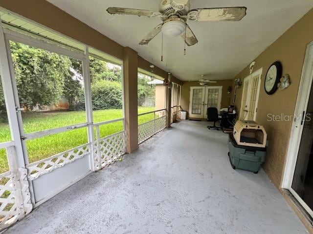 unfurnished sunroom featuring ceiling fan