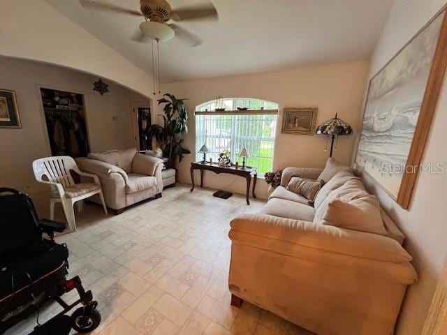 tiled living room with ceiling fan and vaulted ceiling